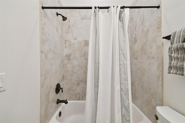bathroom featuring toilet and shower / tub combo with curtain