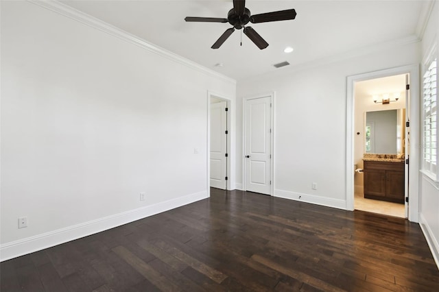 unfurnished bedroom with crown molding, visible vents, ensuite bathroom, baseboards, and dark wood-type flooring