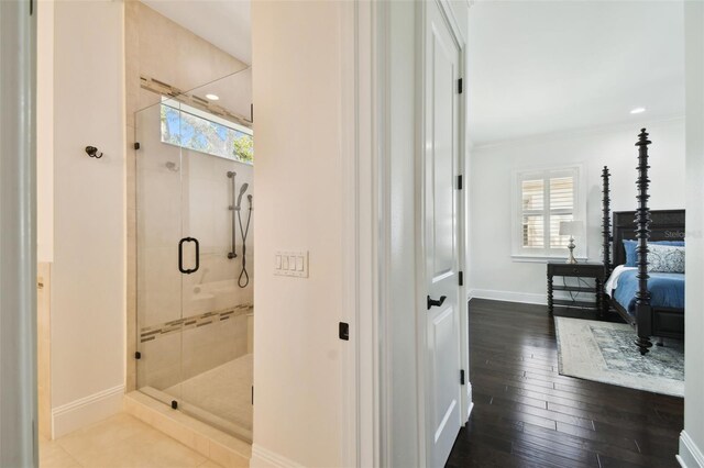 ensuite bathroom featuring baseboards, a shower stall, a wealth of natural light, and ensuite bathroom