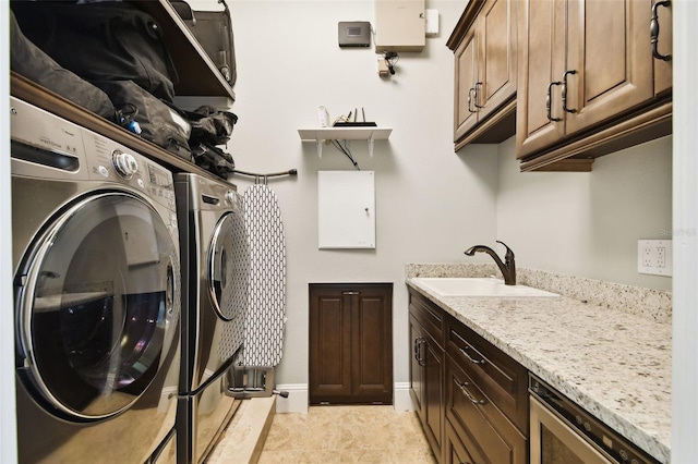 laundry room with a sink, light tile patterned flooring, cabinet space, and washing machine and clothes dryer