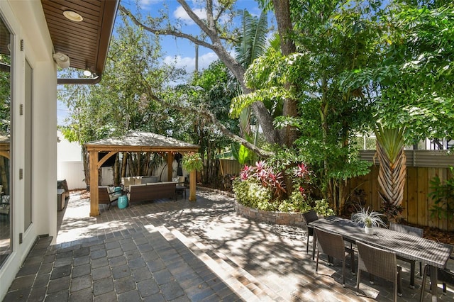view of patio featuring outdoor dining space, an outdoor living space, a gazebo, and a fenced backyard