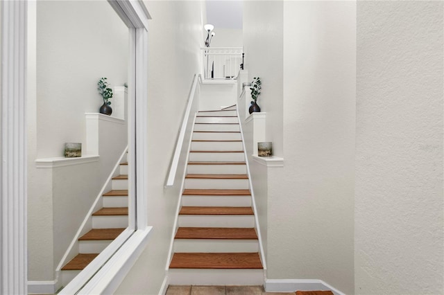 staircase featuring baseboards