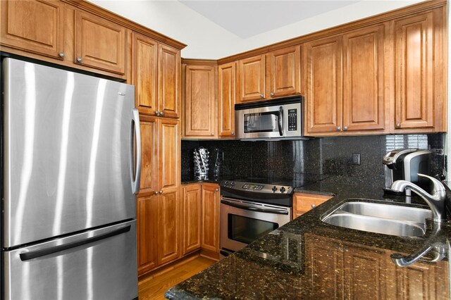 kitchen featuring a sink, tasteful backsplash, brown cabinets, and stainless steel appliances