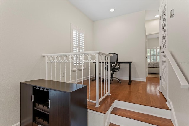 stairway featuring baseboards, recessed lighting, and wood finished floors