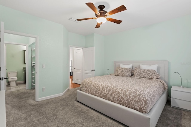 bedroom with ceiling fan, visible vents, baseboards, ensuite bathroom, and carpet flooring