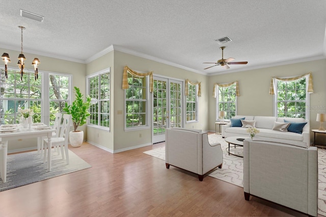 15314 Sherwood Forest Dr, Tampa, FL 33647 - living room featuring wood finished floors, a textured ceiling, ceiling fan, ornamental molding, and a chandelier