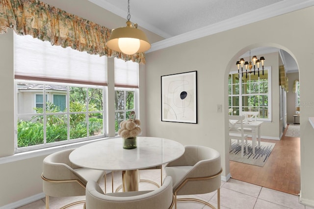 15314 Sherwood Forest Dr, Tampa, FL 33647 - dining area with a chandelier, arched walkways, crown molding, baseboards, and light tile patterned floors