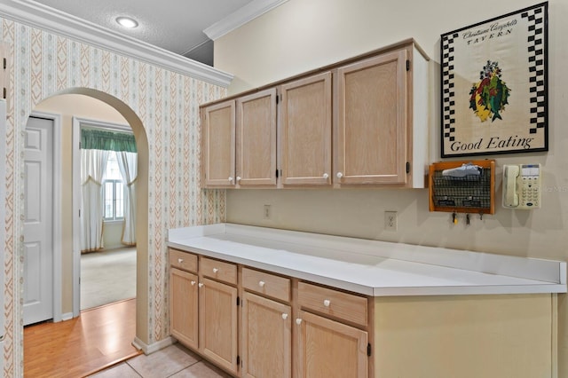 15314 Sherwood Forest Dr, Tampa, FL 33647 - kitchen featuring wallpapered walls, arched walkways, crown molding, light brown cabinets, and light countertops