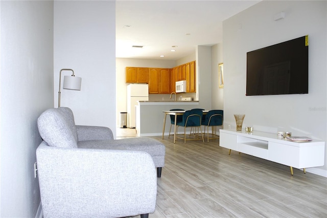living room with light wood finished floors, recessed lighting, and baseboards