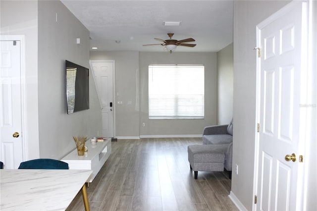 foyer featuring a ceiling fan, wood finished floors, and baseboards