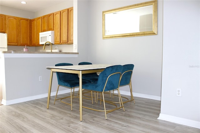 dining space featuring recessed lighting, light wood-style flooring, and baseboards