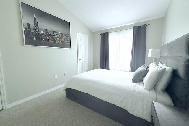 carpeted bedroom featuring lofted ceiling and baseboards