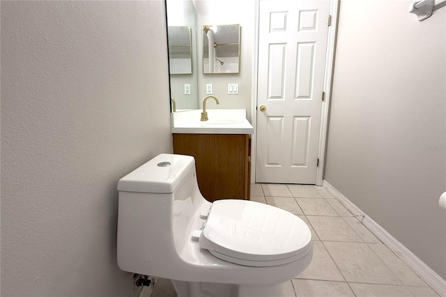 bathroom featuring toilet, tile patterned flooring, vanity, and baseboards