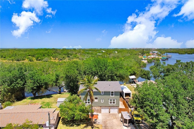 drone / aerial view with a wooded view and a water view