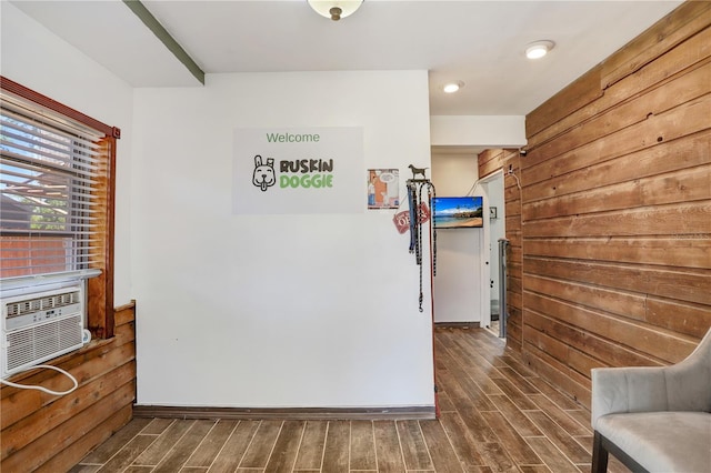 interior space with baseboards, wood finished floors, cooling unit, and wooden walls
