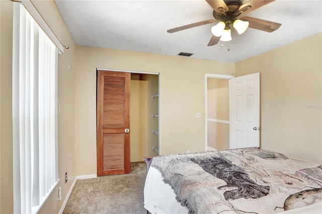 carpeted bedroom featuring baseboards, visible vents, ceiling fan, and a closet