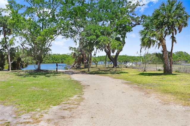 exterior space with a lawn, a water view, and fence