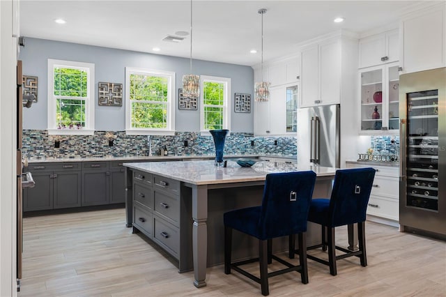 17305 Ballmont Park Dr, Odessa, FL 33556 - kitchen featuring white cabinetry, gray cabinets, high end refrigerator, and tasteful backsplash