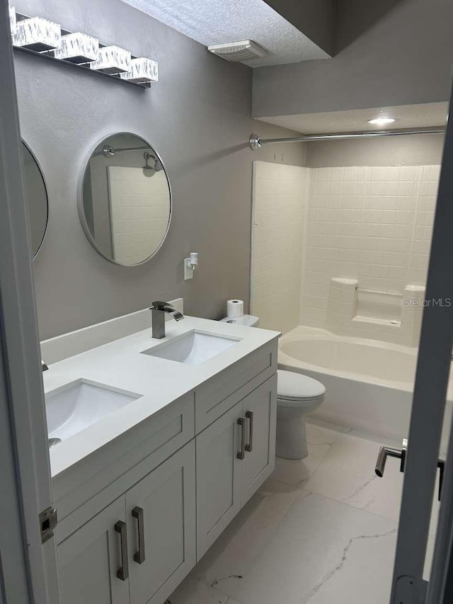 full bathroom featuring toilet, marble finish floor, a sink, and double vanity