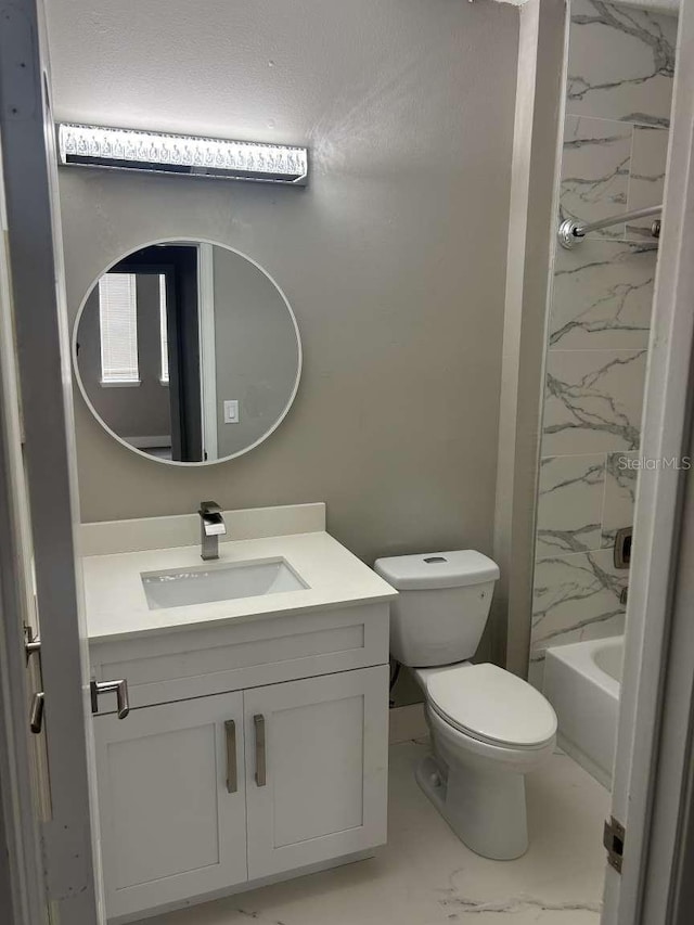 full bath featuring toilet, vanity, and marble finish floor