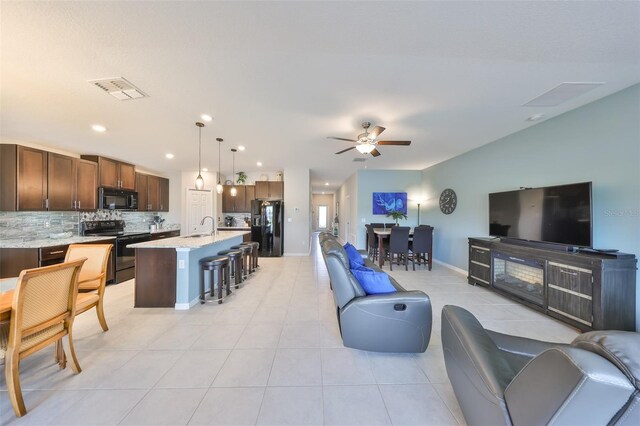 15426 Wicked Strong St, Sun City Center, FL 33573 - living room with ceiling fan, light tile patterned flooring, baseboards, and recessed lighting