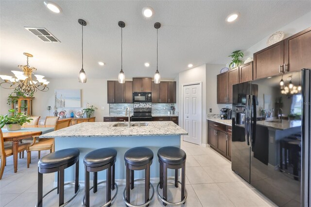 15426 Wicked Strong St, Sun City Center, FL 33573 - kitchen with black appliances, a sink, tasteful backsplash, a chandelier, and a kitchen bar