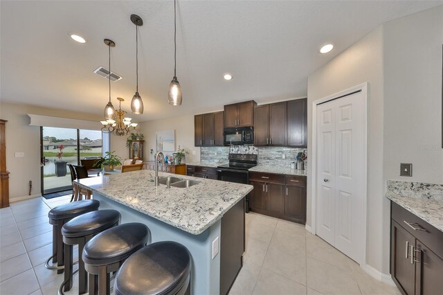 15426 Wicked Strong St, Sun City Center, FL 33573 - kitchen featuring black appliances, a sink, a breakfast bar area, a chandelier, and decorative backsplash