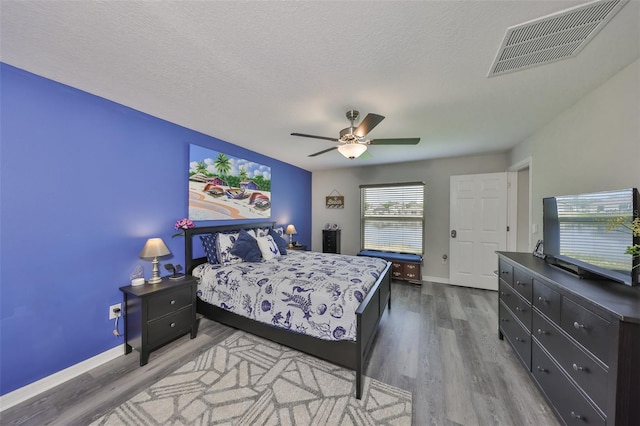 15426 Wicked Strong St, Sun City Center, FL 33573 - bedroom with wood finished floors, baseboards, ceiling fan, and a textured ceiling