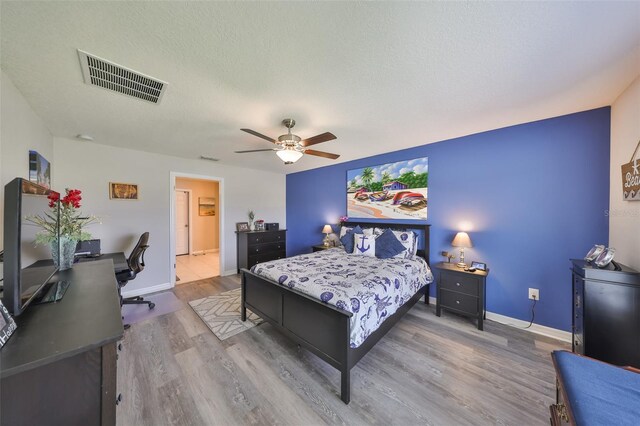 15426 Wicked Strong St, Sun City Center, FL 33573 - bedroom with wood finished floors, a desk, ceiling fan, and baseboards