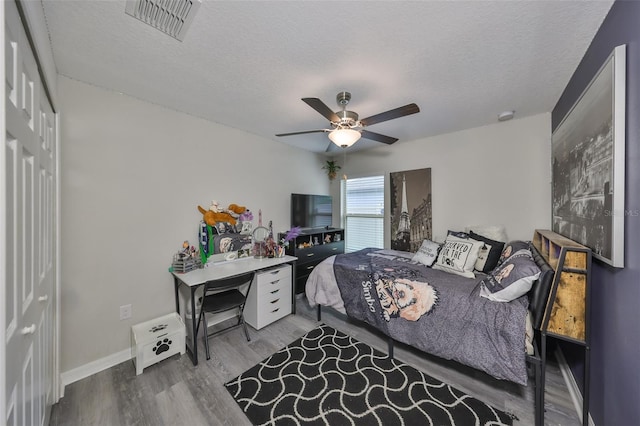 15426 Wicked Strong St, Sun City Center, FL 33573 - bedroom featuring wood finished floors, a textured ceiling, ceiling fan, and baseboards
