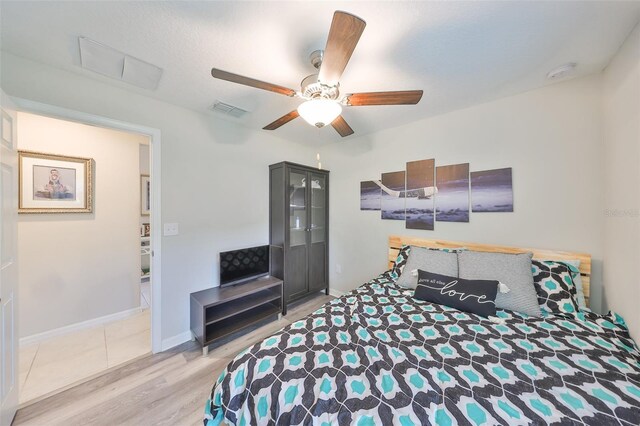 15426 Wicked Strong St, Sun City Center, FL 33573 - bedroom with light wood-type flooring, a ceiling fan, and baseboards