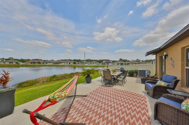 15426 Wicked Strong St, Sun City Center, FL 33573 - view of patio / terrace with a water view, outdoor dining space, central air condition unit, and a residential view