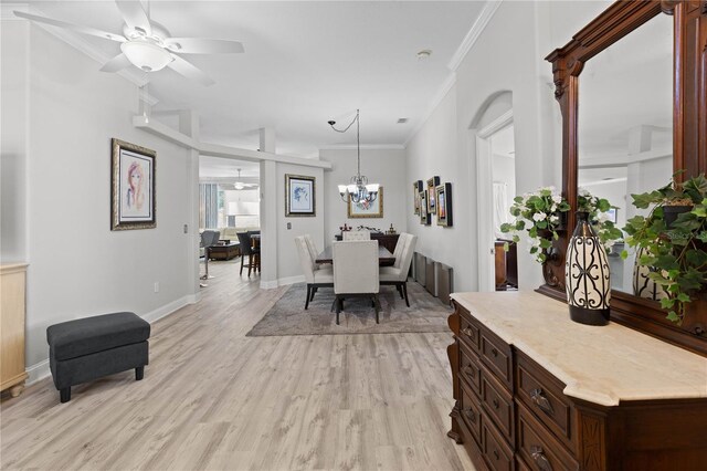 9723 Rolling Cir, San Antonio, FL 33576 - dining room featuring light wood-type flooring, ornamental molding, baseboards, and ceiling fan with notable chandelier