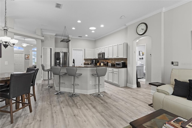 9723 Rolling Cir, San Antonio, FL 33576 - living area with crown molding, a ceiling fan, visible vents, and light wood-style flooring