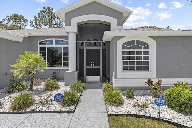 9723 Rolling Cir, San Antonio, FL 33576 - doorway to property featuring a shingled roof and stucco siding