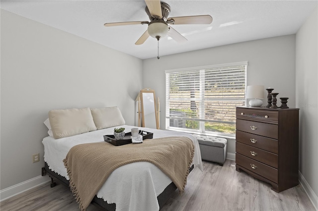 9723 Rolling Cir, San Antonio, FL 33576 - bedroom with baseboards, a ceiling fan, and light wood-style flooring