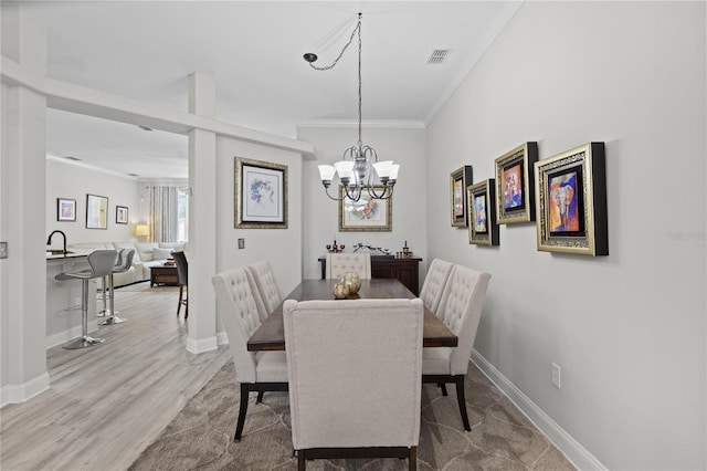 9723 Rolling Cir, San Antonio, FL 33576 - dining space with visible vents, crown molding, light wood-type flooring, baseboards, and a chandelier