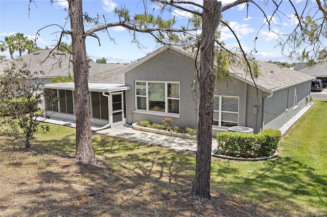 9723 Rolling Cir, San Antonio, FL 33576 - rear view of house with a yard, a sunroom, and stucco siding