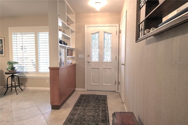 doorway to outside featuring light tile patterned floors and baseboards