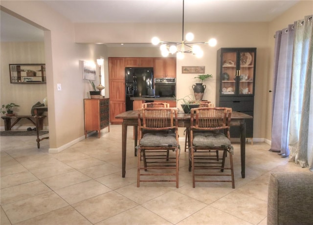 dining area featuring light tile patterned floors, baseboards, and a notable chandelier