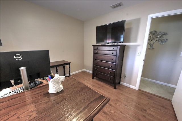 office space featuring visible vents, baseboards, and wood finished floors