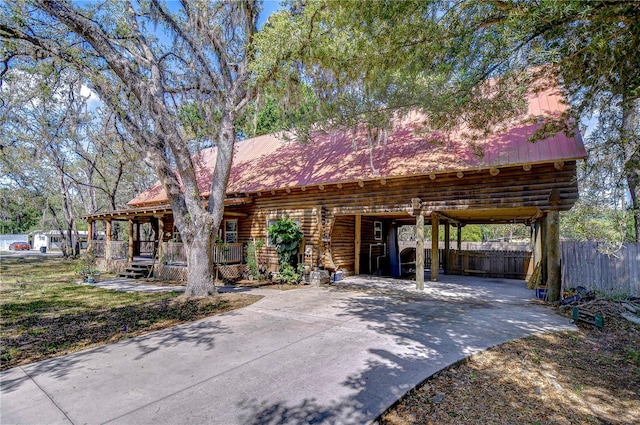 4126 Burrows Rd, Zephyrhills, FL 33542 - view of front facade featuring fence, metal roof, a porch, and log siding