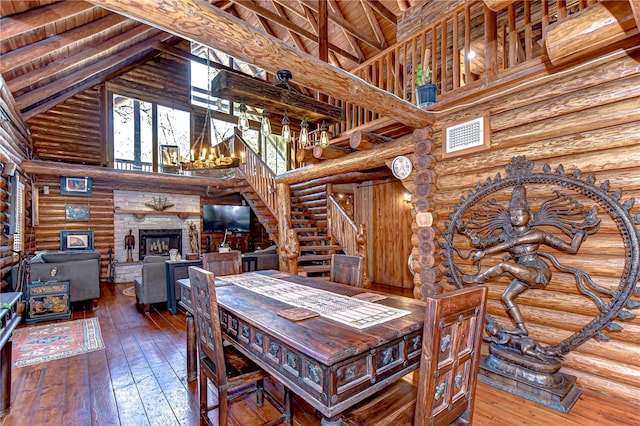 4126 Burrows Rd, Zephyrhills, FL 33542 - dining area with high vaulted ceiling, rustic walls, and hardwood / wood-style flooring