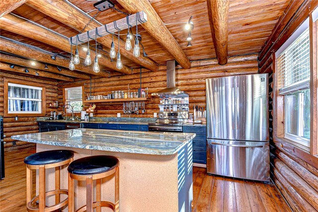 4126 Burrows Rd, Zephyrhills, FL 33542 - kitchen with stainless steel appliances, wood-type flooring, blue cabinetry, wall chimney exhaust hood, and wood ceiling