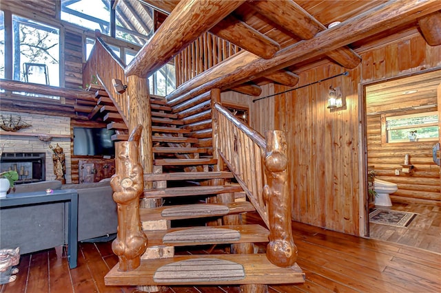 4126 Burrows Rd, Zephyrhills, FL 33542 - staircase featuring beam ceiling, hardwood / wood-style flooring, and a stone fireplace