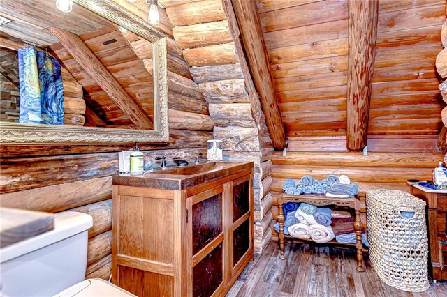4126 Burrows Rd, Zephyrhills, FL 33542 - bathroom featuring rustic walls, vanity, toilet, and hardwood / wood-style flooring