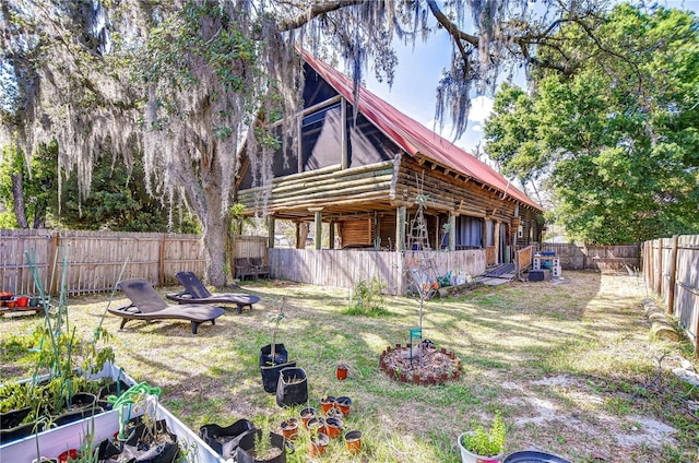 4126 Burrows Rd, Zephyrhills, FL 33542 - back of property featuring log exterior, metal roof, and a fenced backyard
