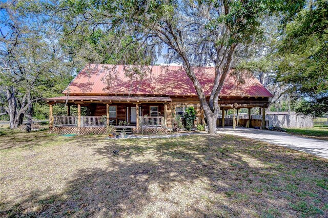 4126 Burrows Rd, Zephyrhills, FL 33542 - view of front of property with a porch, metal roof, driveway, a carport, and fence