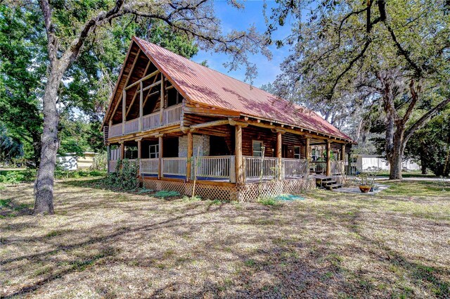 4126 Burrows Rd, Zephyrhills, FL 33542 - view of side of property featuring metal roof, a porch, and stone siding
