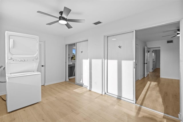 1225 58th St N Unit 204A, Saint Petersburg, FL 33710 - clothes washing area featuring stacked washer / dryer, a ceiling fan, light wood finished floors, and baseboards